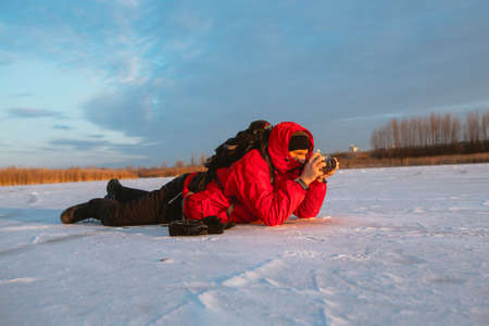 Photographer take  pictures on the river bank in winterの写真素材