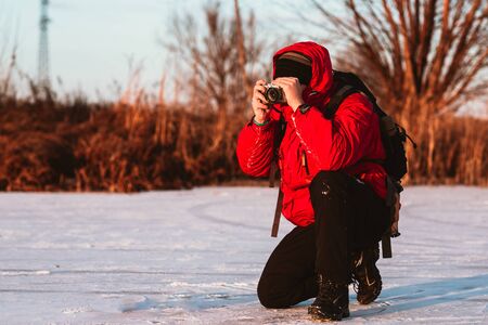 Photographer take  pictures on the river bank in winterの写真素材