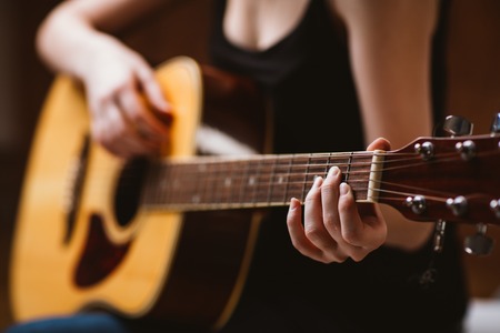 woman's hands playing  acoustic guitar, close upの写真素材