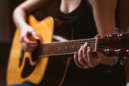 woman's hands playing  acoustic guitar, close upの写真素材