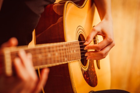 woman's hands playing  acoustic guitar, close upの写真素材