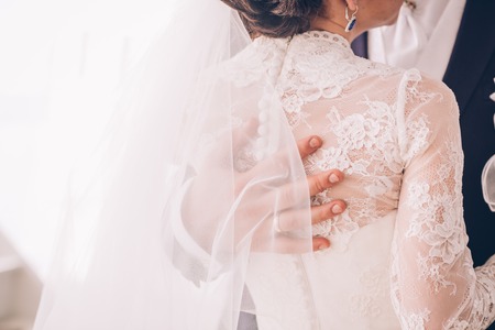 Groom hand on brides dress at wedding  danceの写真素材