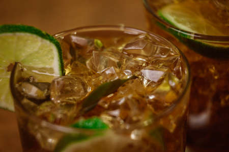 drink concept - cocktail with  cola ice cubes and limeの写真素材