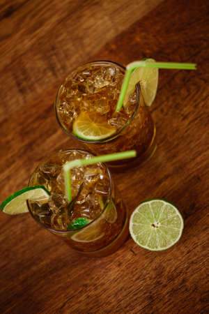 drink concept - cocktail with  cola ice cubes and limeの写真素材