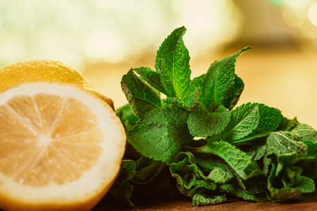 lemons and mint on  a dark wood background. tinting. selective focus