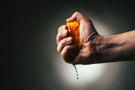 man squeezes orange.の写真素材