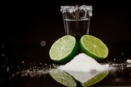 Tequila with lime and salt on black backgroundの写真素材