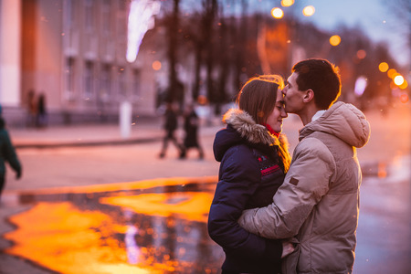 Portrait of young beautiful couple kissing in an autumn rainy dayの写真素材