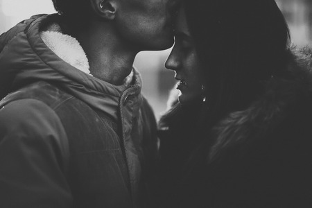 Close-up image of couple in love, man kisses a woman. Black-white photo.の写真素材