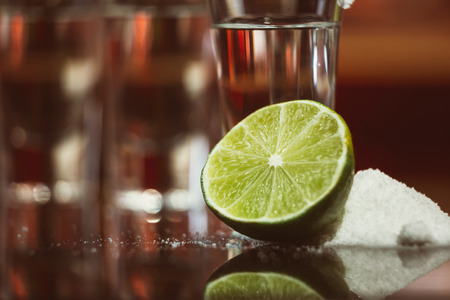 tequila with lime and salt on a wooden tableの写真素材