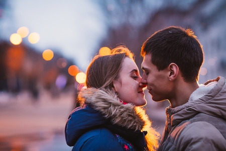 Portrait of young beautiful couple kissing in an autumn rainy dayの写真素材