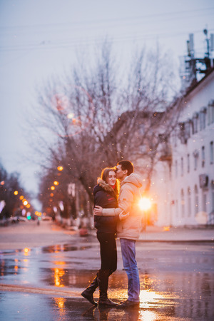 Portrait of young beautiful couple kissing in an autumn rainy dayの写真素材