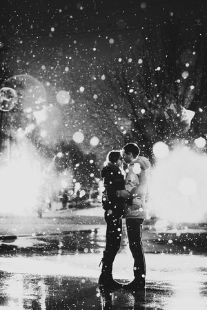 In love couple in the snow at night city, street black and whiteの写真素材