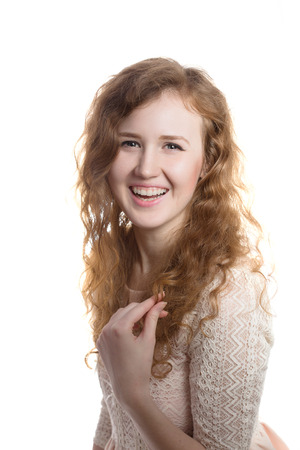 Young pretty curly girl in pink dress smilingの写真素材