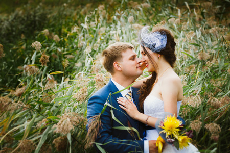 happy bride, groom standing in green park, smiling, laughing. lovers in wedding  day.の写真素材