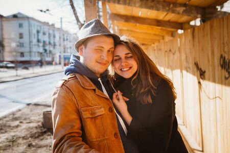 portrait of a beautiful couple walking in the street in summer, they wear hat and making selfieの写真素材