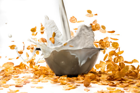 pouring milk into corn flakes creating  splashの写真素材