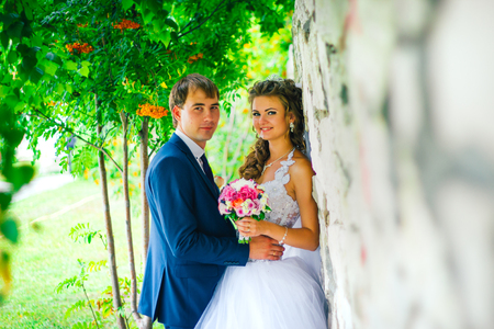 Beautiful  young couple standing on a stone wall backgroundの写真素材