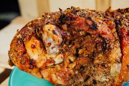 great fresh baked turkey  leg and sliced piece sprinkled with spices lying on a blue plate to black wooden backgroundの写真素材