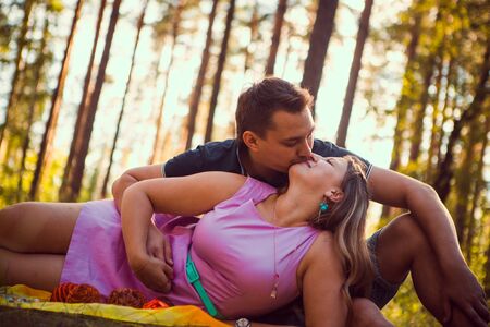 Romantic young couple kissing  on background summer forestの写真素材