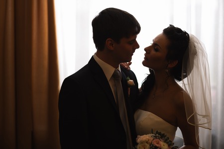 beautiful young  couple standing near the windowの写真素材