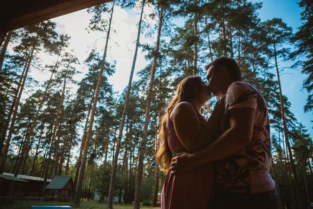 Romantic young couple kissing  on background summer forestの写真素材