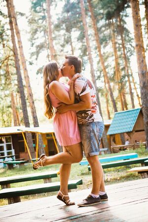 Romantic young couple kissing  on background summer forestの写真素材