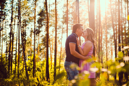 Romantic young couple kissing  on background summer forestの写真素材