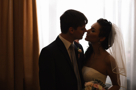 beautiful young  couple standing near the windowの写真素材
