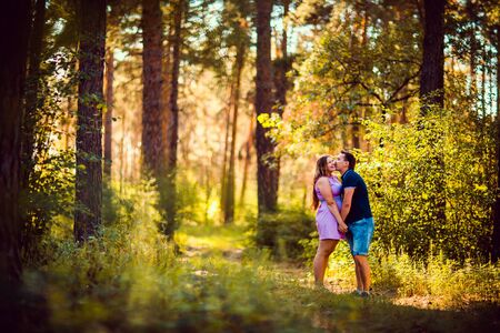 Romantic young couple kissing  on background summer forestの写真素材