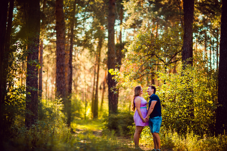 Romantic young couple kissing  on background summer forestの写真素材