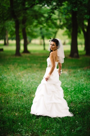 beautiful young bride stand on  background forestの写真素材