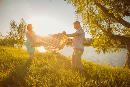 Romantic couple put a  blanket on background summer lakeの写真素材