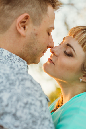 Romantic couple standing  and kissing on background summer lake sunsetの写真素材