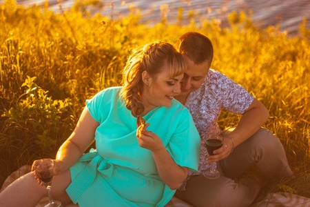 Romantic  couple sit and  kissing  on background summer lakeの写真素材