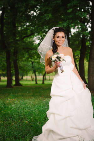 beautiful young bride stand on  background forestの写真素材