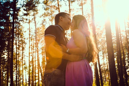 Romantic young couple kissing  on background summer forestの写真素材