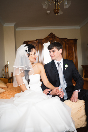 beautiful young  couple sitting on the bedの写真素材