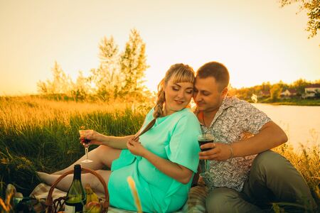 Romantic  couple sit and  kissing  on background summer lakeの写真素材
