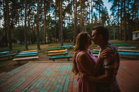 Romantic young couple kissing  on background summer forestの写真素材
