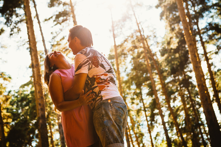 Romantic young couple kissing  on background summer forestの写真素材
