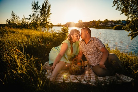 Romantic  couple sit and  kissing  on background summer lakeの写真素材