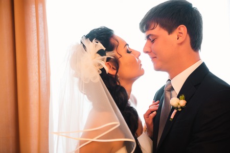 beautiful young  couple standing near the windowの写真素材
