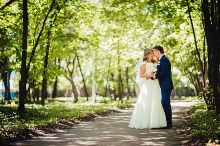 Happy couple  bride and groom embracing they stand in a forest full lengthの写真素材