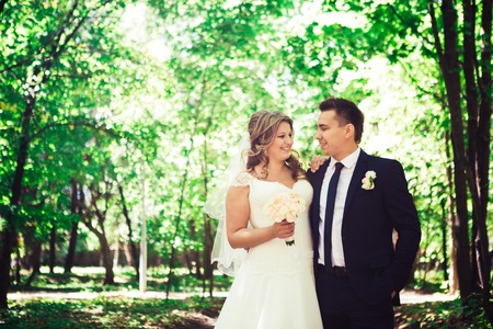 Happy couple bride and groom embracing they stand  in a forestの写真素材