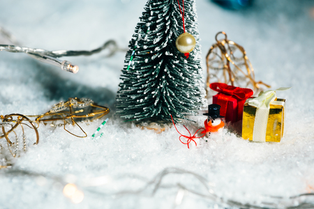 miniature Christmas tree, snowman  and gifts in the snowの写真素材