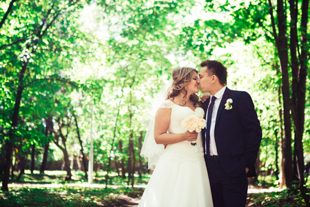 Happy couple bride and groom embracing they stand  in a forestの写真素材
