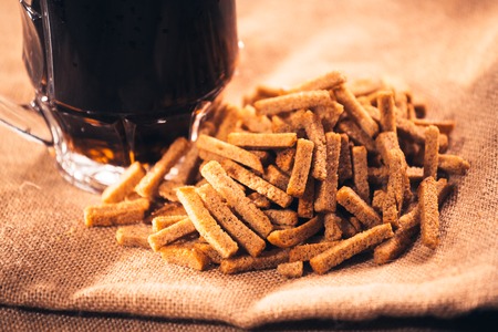 A glass of fresh beer and crackers on sackingの写真素材