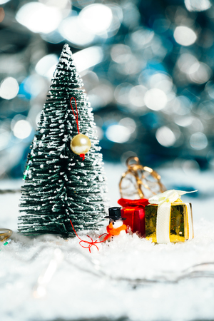 miniature Christmas tree, snowman  and gifts in the snowの写真素材
