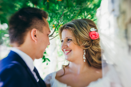 Happy couple  bride and groom embracing they stand on background stone wall close-upの写真素材